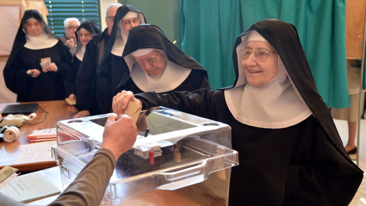 A Benedictine sister of the Sainte-Cecile Abbey casts her ballot at a polling station in Solesmes, northwestern France, on Sunday.