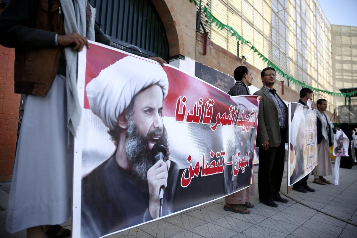 Houthi rebels hold posters of Shiite cleric Nimr al-Nimr, who was executed in Saudi Arabia, during a protest Thursday at the Saudi embassy in Sana, Yemen.