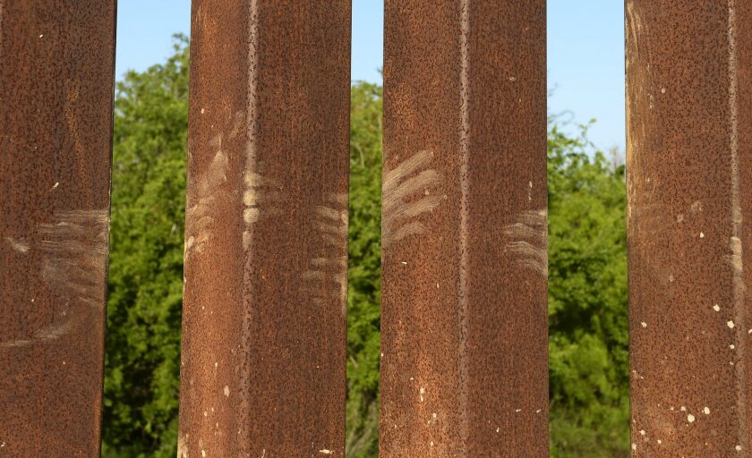 Muddy hand prints on the border fence left by people climbing over from Mexico along the Rio Grande near McAllen, Texas.