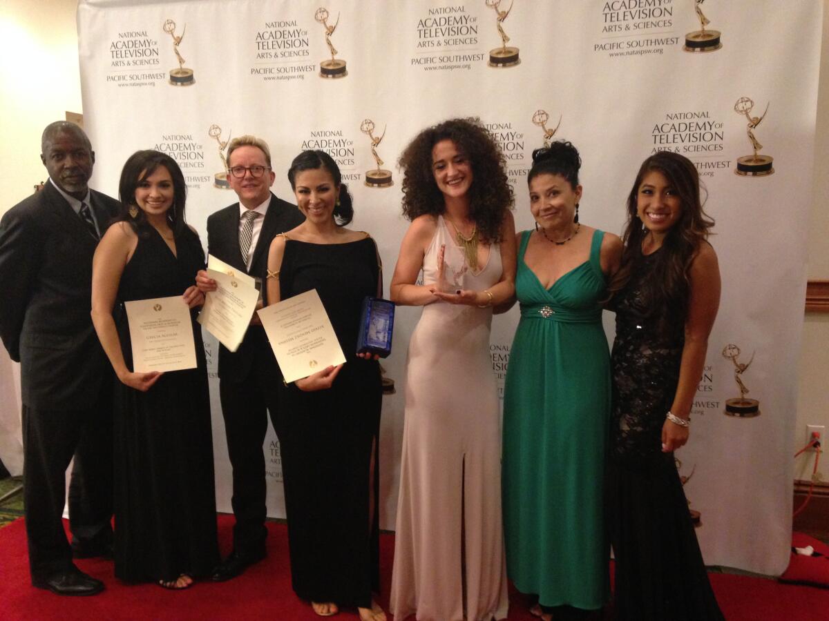 Professor Laura Castañeda poses with Emmy award student winners,  in 2014.