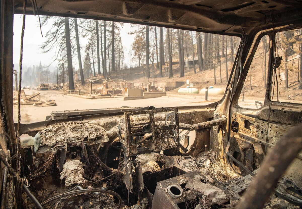 The inside of a burned fire engine smolders in a decimated downtown Greenville, Calif.