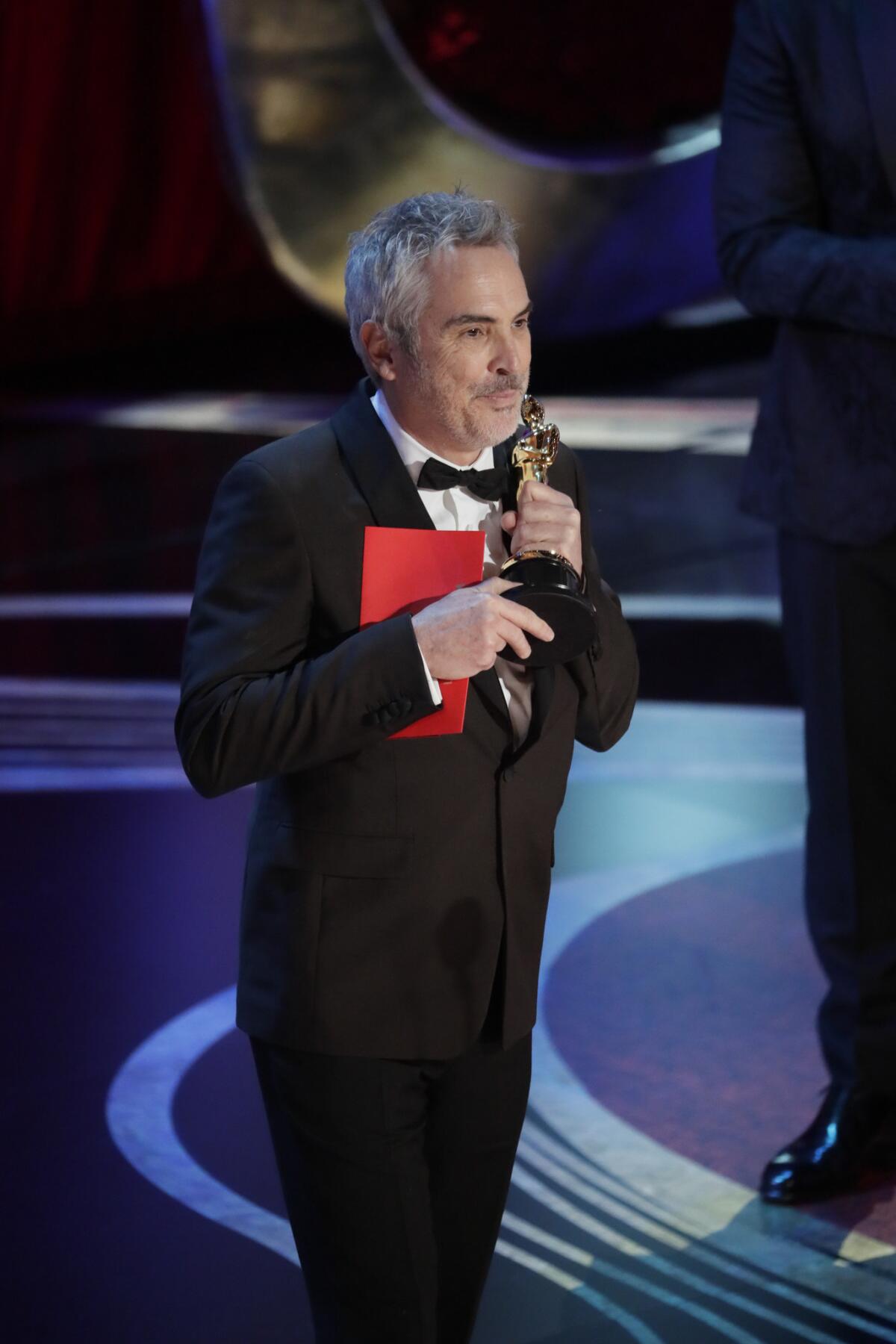 "Roma" writer-director Alfonso Cuarón accepts one of the film's three Oscar wins during the telecast of the 91st Academy Awards.