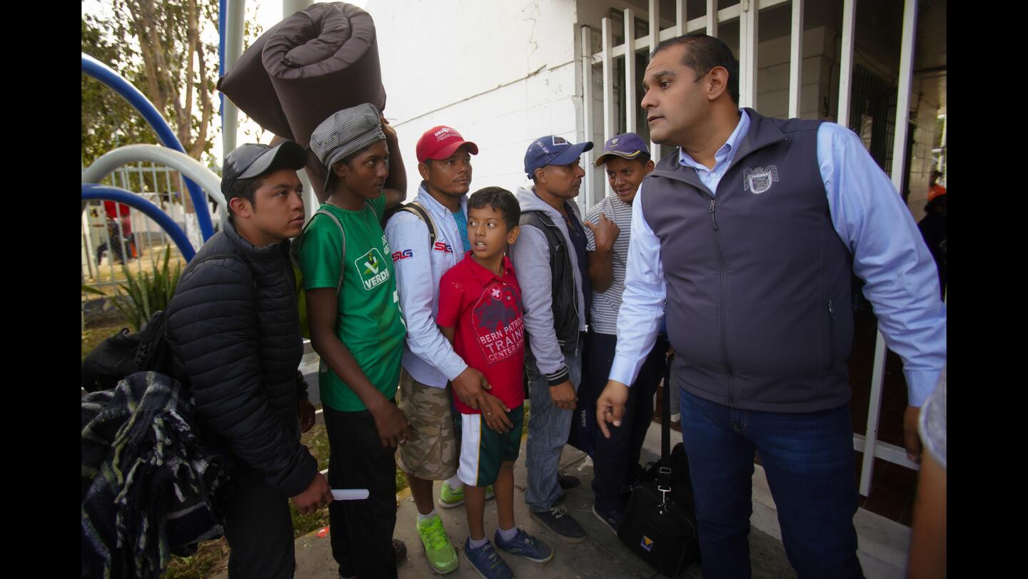 Men stand outside the temporary shelter set up at the Unidad Deportiva Benito Juarez in Tijuana hoping to get in for the evening.