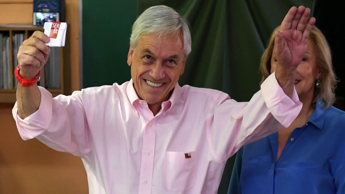 Chile's presidential candidate Sebastian Piñera prepares to cast his vote, next to his wife, Cecilia Morel, during the presidential runoff election in Santiago on Dec. 17, 2017.