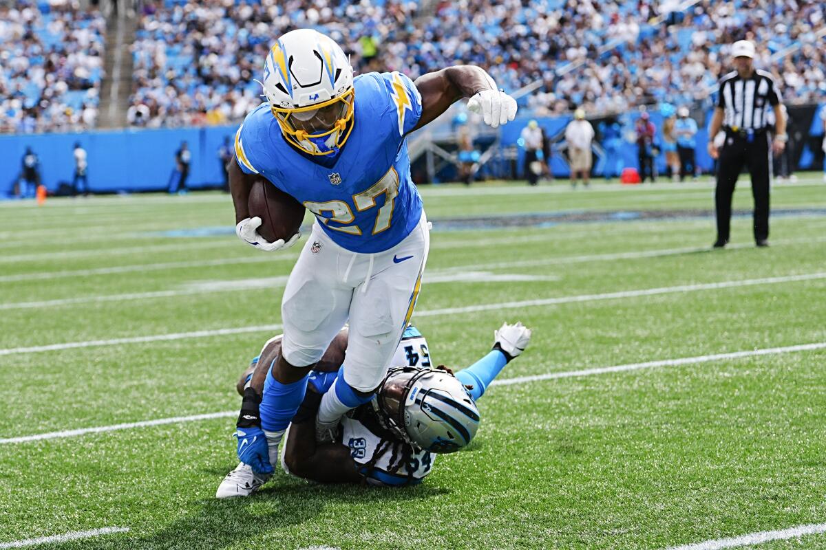  Chargers running back J.K. Dobbins is tackled by Panthers linebacker Shaq Thompson.