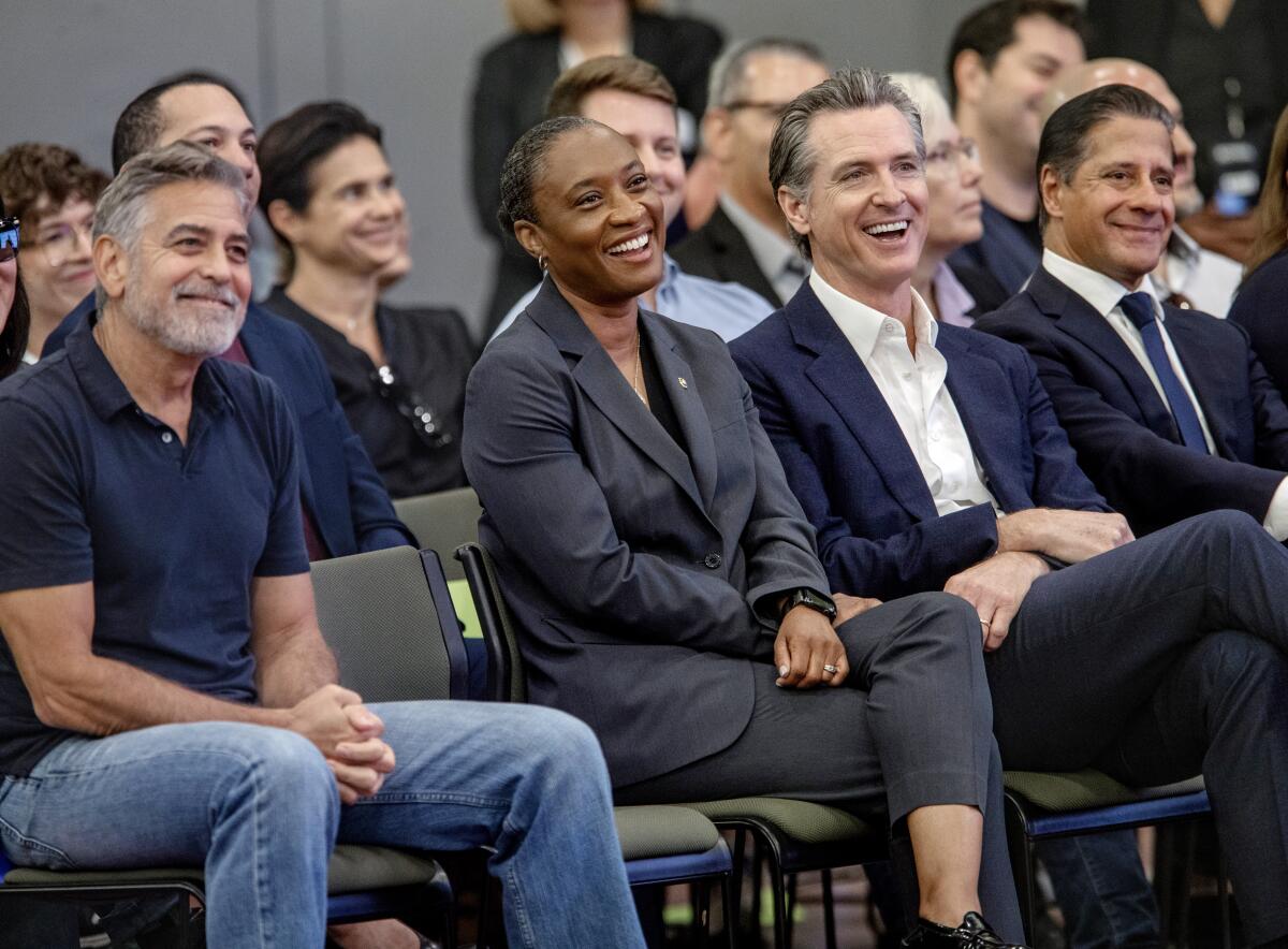 Actor George Clooney, Sen. Laphonza Butler, Gov. Gavin Newsom and LAUSD Supt. Alberto Carvalho laugh at an event