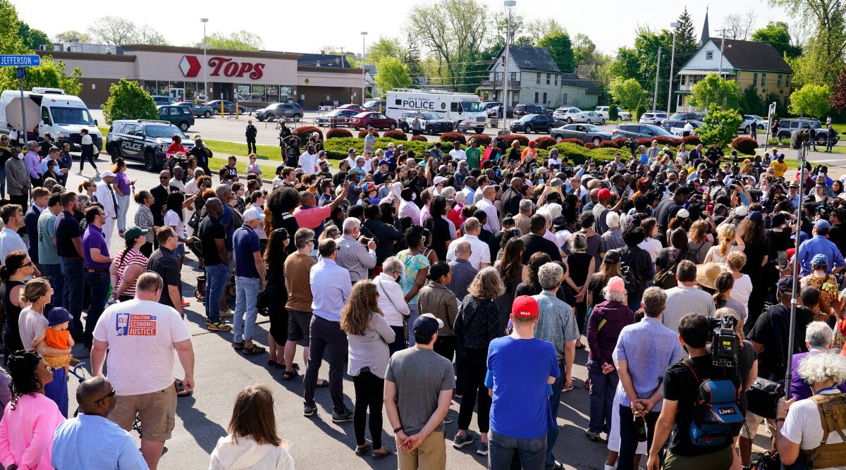 A crowd gathers outside a supermarket, the scene of a shooting, in Buffalo, N.Y.
