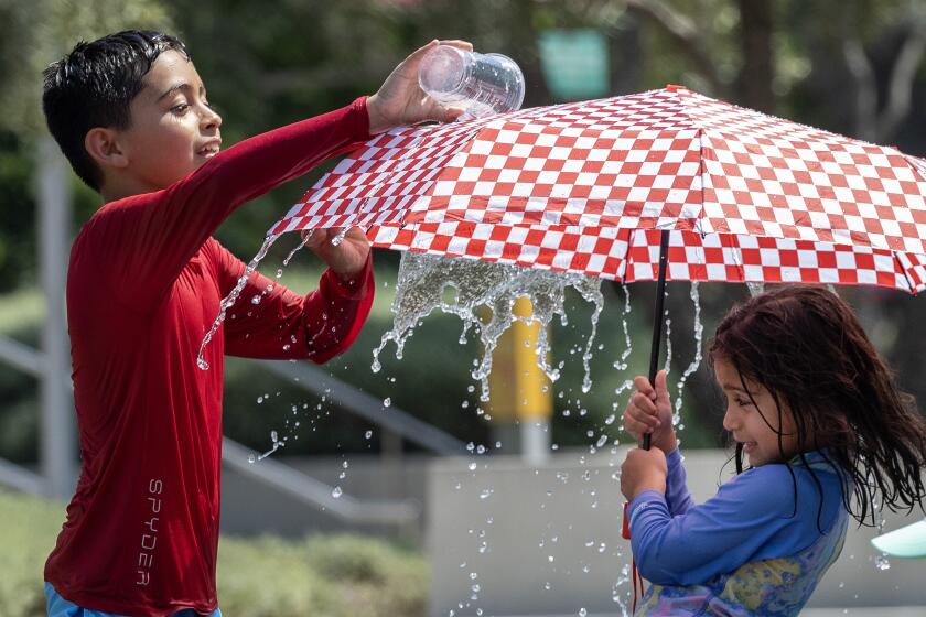 LOS ANGELES, CA - SEPTEMBER 07: Dean Lagunas, 9, cools off with his sister Delilah, 6, in the Arthur J. Will Memorial Fountain at Grand Park while attending a friend's birthday party on Saturday, Sept. 7, 2024. (Myung J. Chun / Los Angeles Times)