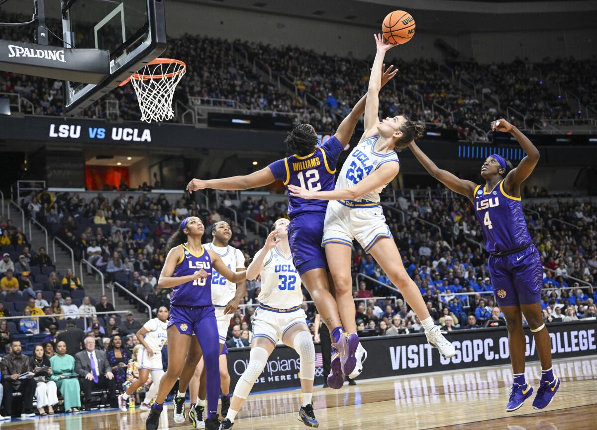 LSU guard Mikaylah Williams and UCLA forward Gabriela Jaquez battle for the ball during their Sweet 16 matchup 