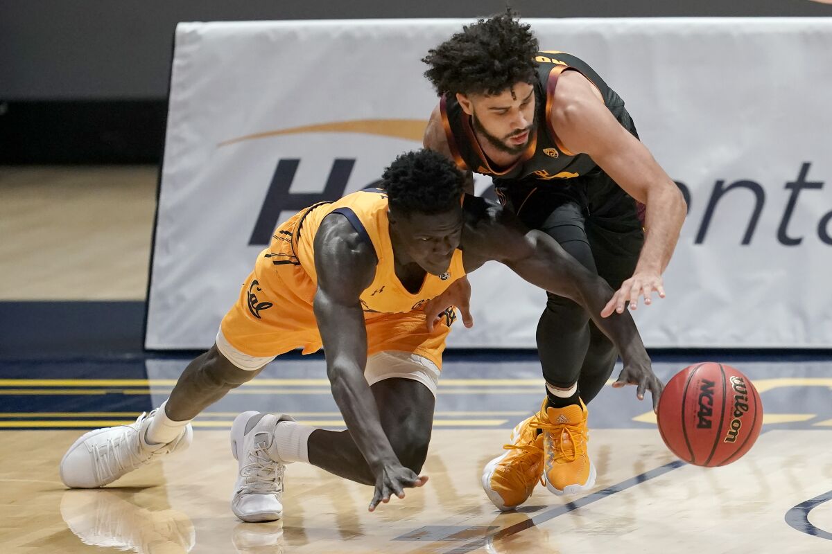 California forward Kuany Kuany, left, reaches for the ball under Arizona State guard Holland Woods during the first half of an NCAA college basketball game in Berkeley, Calif., Thursday, Dec. 3, 2020. (AP Photo/Jeff Chiu)