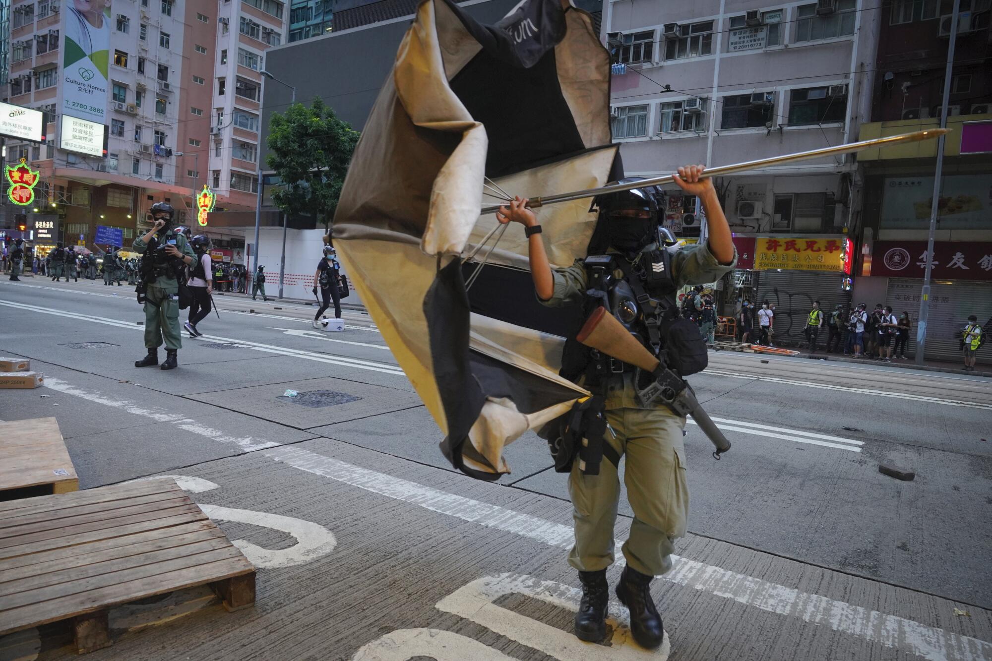 Police remove a giant umbrella roadblock from a main road in Hong Kong on Wednesday.