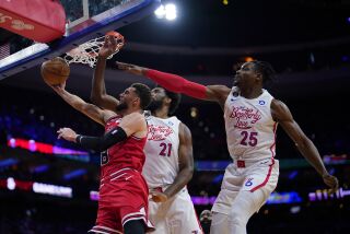 Zach LaVine, izquierda, de los Bulls de Chicago, se levanta para tomar un tiro en contra de la presión defensiva de Joel Embiid, centro, y Danuel House Jr., de los 76ers de Filadelfia, durante el juego de baloncesto de la NBA, el lunes 20 de marzo de 2023, en Filadelfia. (AP Foto/Matt Slocum)