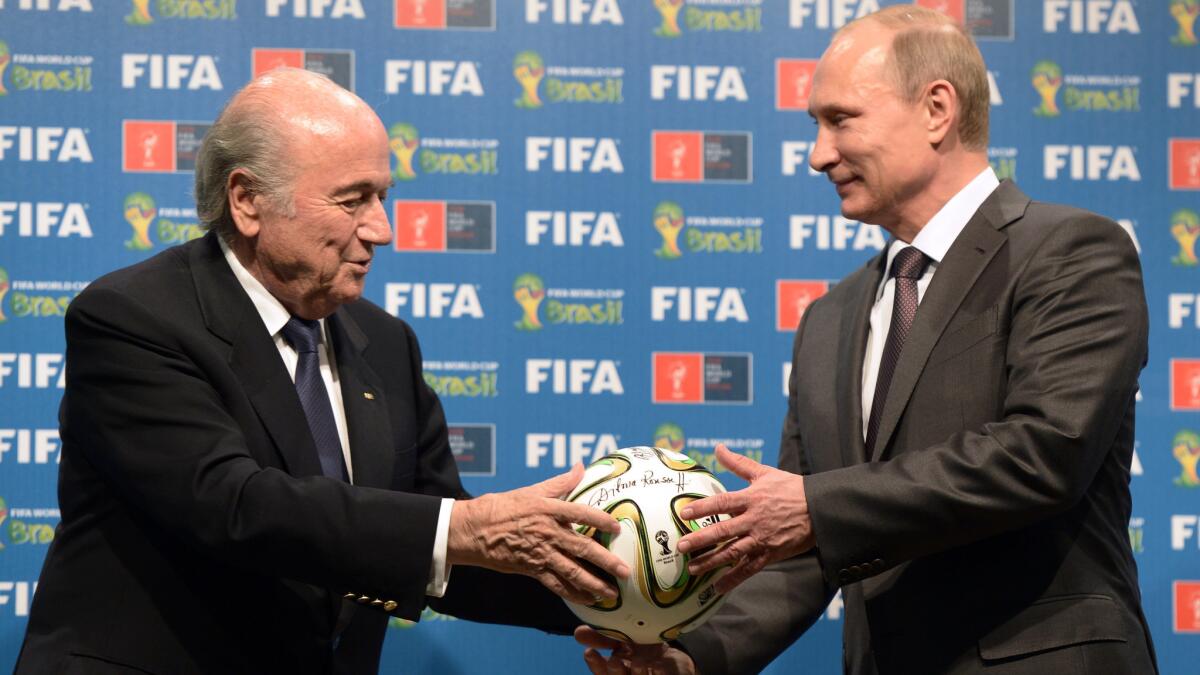 FIFA President Sepp Blatter, left, passes a soccer ball to Russian President Vladimir Putin in 2014 during the official handover ceremony of the 2018 World Cup to Russia.