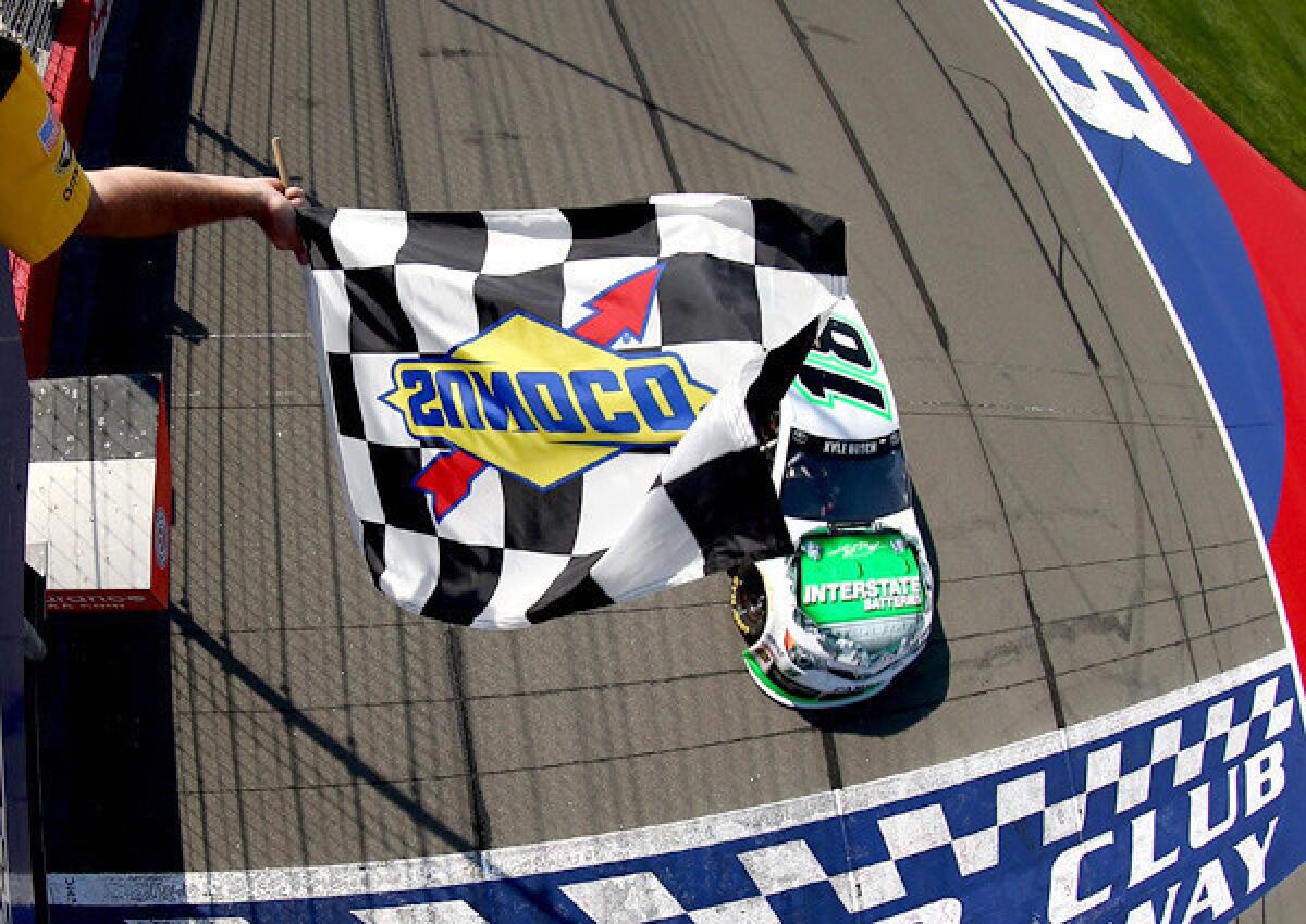 Kyle Busch drives his No. 18 Interstate Batteries Toyota across the finish line to win the NASCAR Sprint Cup Auto Club 500 on Sunday in Fontana.