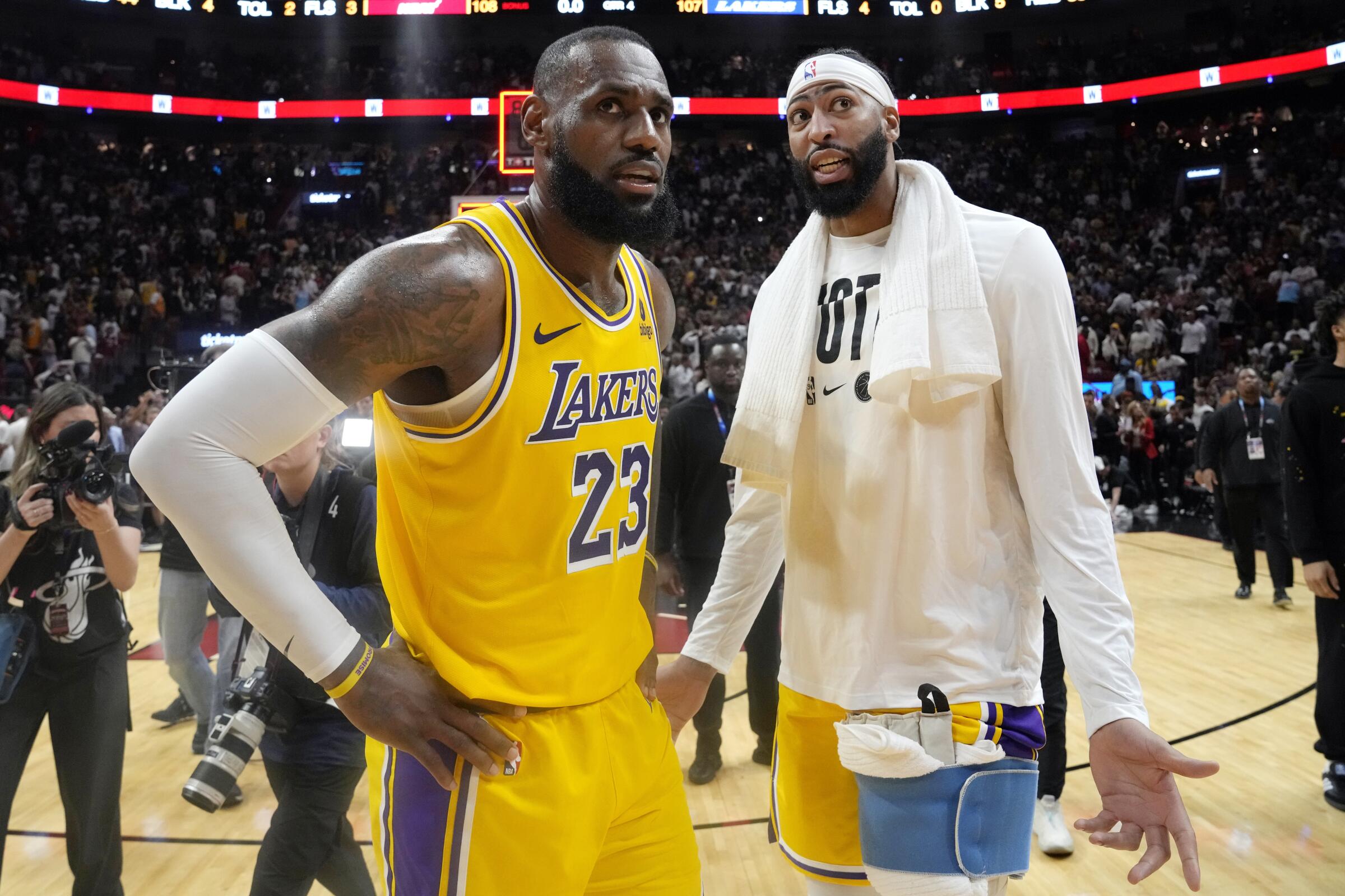 Lakers forward LeBron James, left, and forward Anthony Davis stand on the court after a 108-107 loss to the Miami Heat.