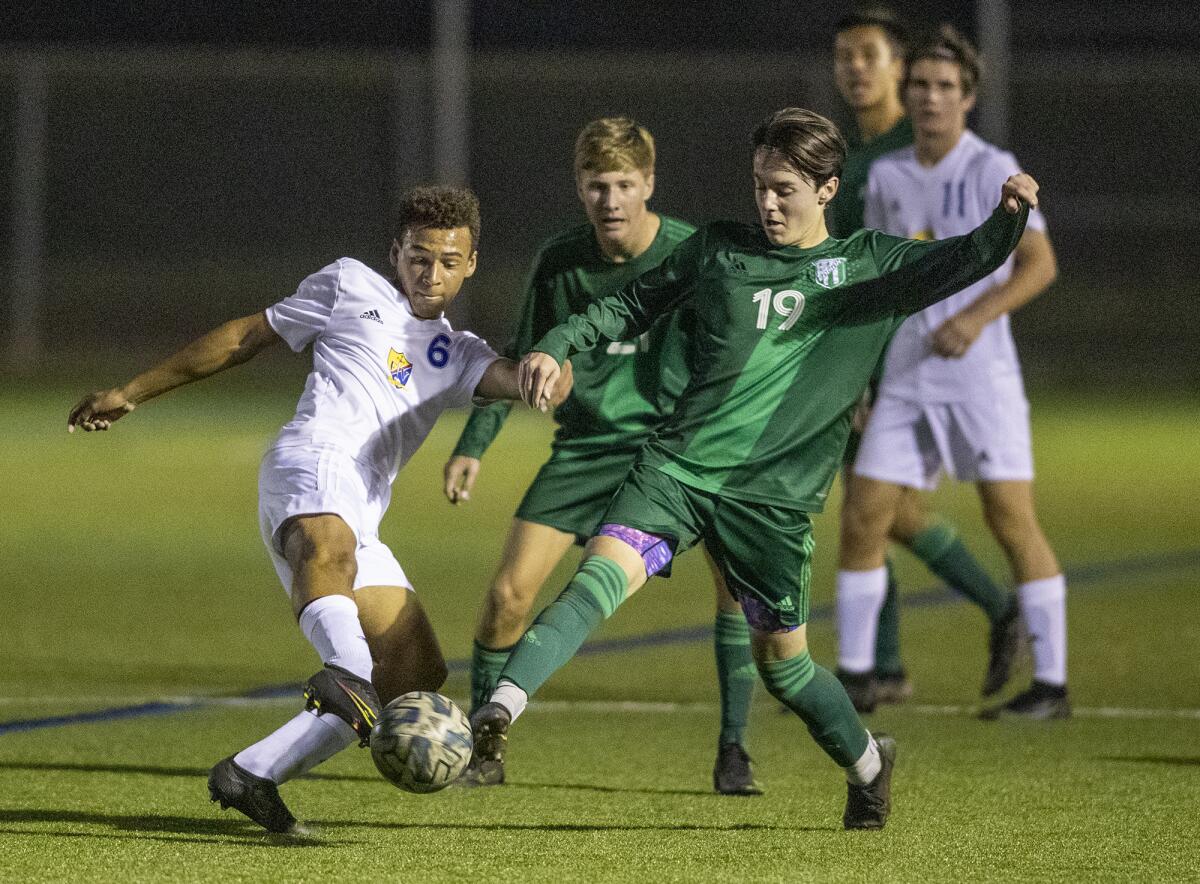 Fountain Valley's Micah Yanez and Edison's Tony Jordan battle for a ball during a Surf League boys' soccer match.