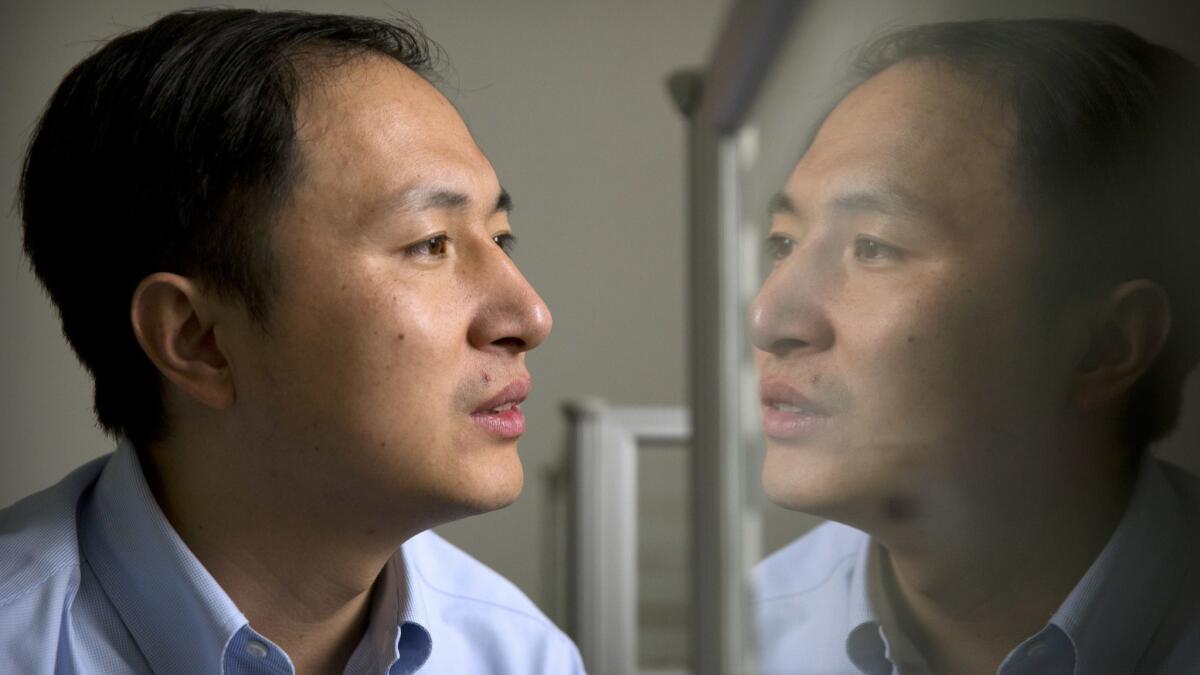 Researcher He Jiankui is reflected in a glass panel as he works at a computer at a laboratory in Shenzhen in southern China's Guangdong province on Oct. 10.