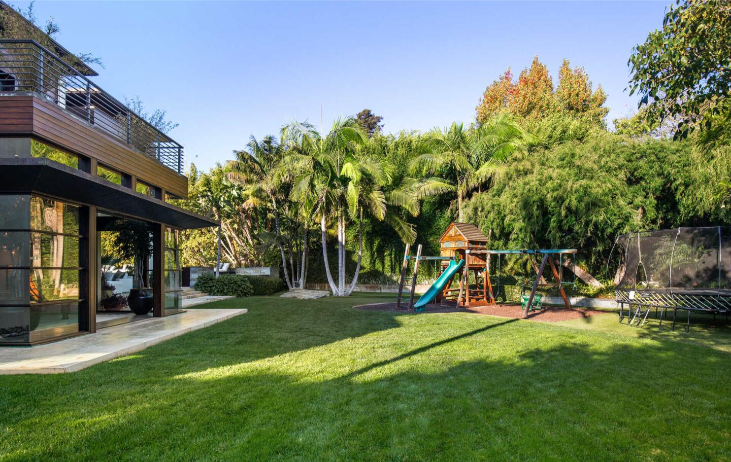 The lawn with trees and the house nearby.