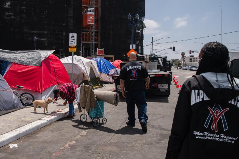 Craig Thomas and Ionia Honeycutt, outreach specialists of Alpha Project talk to people living on the street asking if they would like to go to a shelter in downtown San Diego on on May 13, 2021.