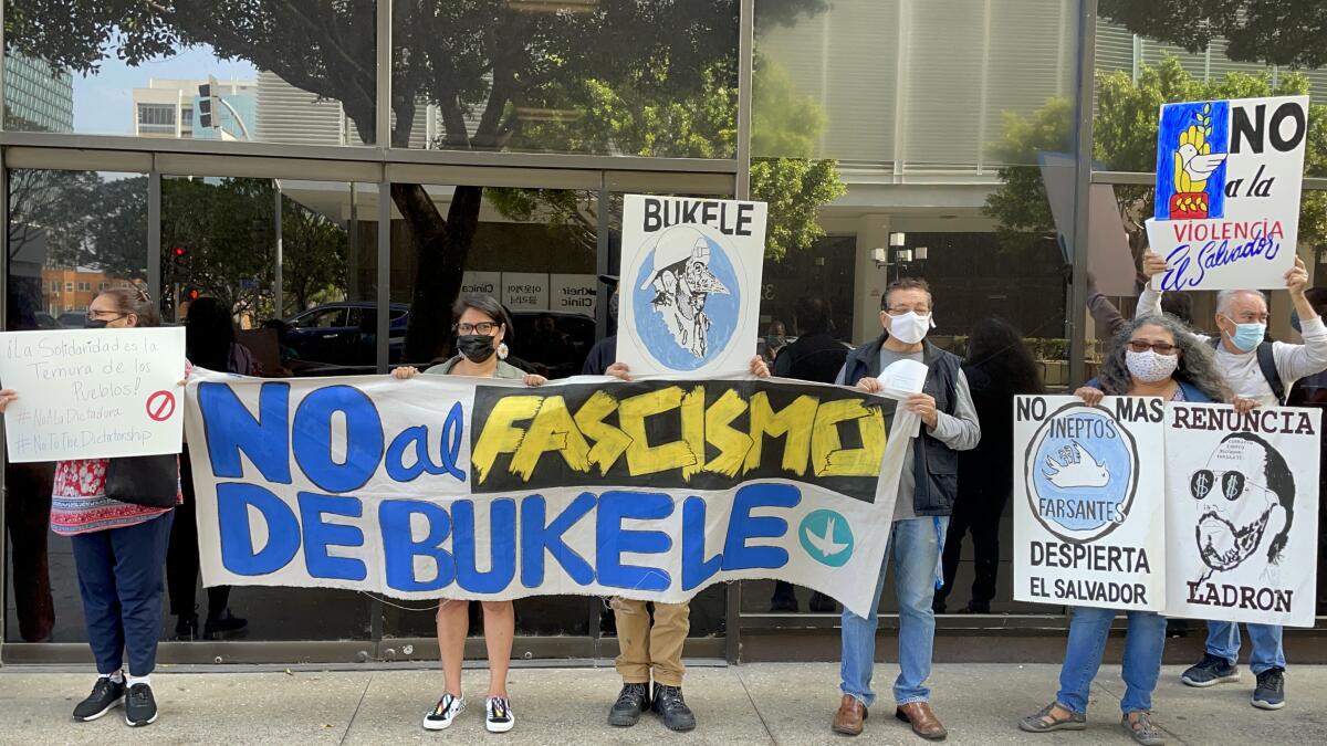 People hold signs reading "No al Fascismo, de Bukele."