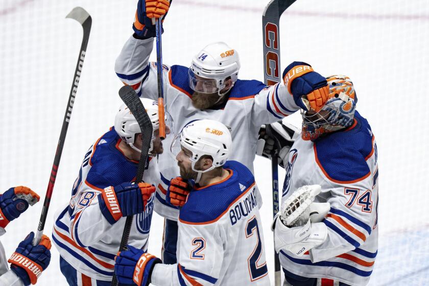 Edmonton Oilers' Mattias Ekholm (14), goalie Stuart Skinner (74), Evan Bouchard (2) and Zach Hyman (18) celebrate after winning against the Vancouver Canucks in Game 7 of an NHL hockey Stanley Cup second-round playoff series, in Vancouver, British Columbia, on Monday, May 20, 2024. (Ethan Cairns/The Canadian Press via AP)