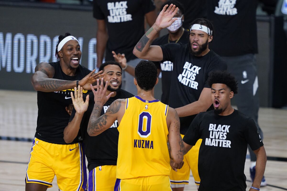 Los Angeles Lakers' Kyle Kuzma (0) is congratulated by teammates after hitting a game-winning 3-pointer against the Denver Nuggets during the second half of an NBA basketball game Monday, Aug. 10, 2020, in Lake Buena Vista, Fla. The Lakers won 124-121. (AP Photo/Ashley Landis, Pool)