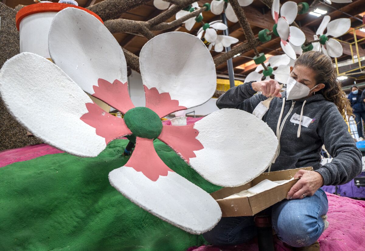Nathalie Herron decorates a flower on a Rose Parade float