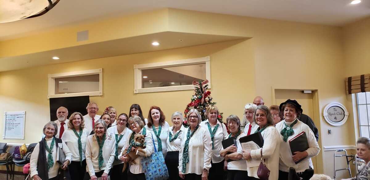 The Ramona Community Singers at a 2019 performance at a nursing home with mascot Nutmeg. 