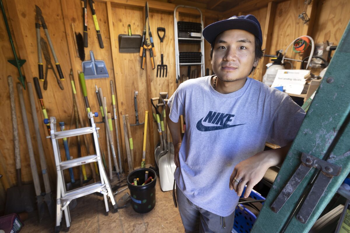 A man stands in a tool lending library shed.