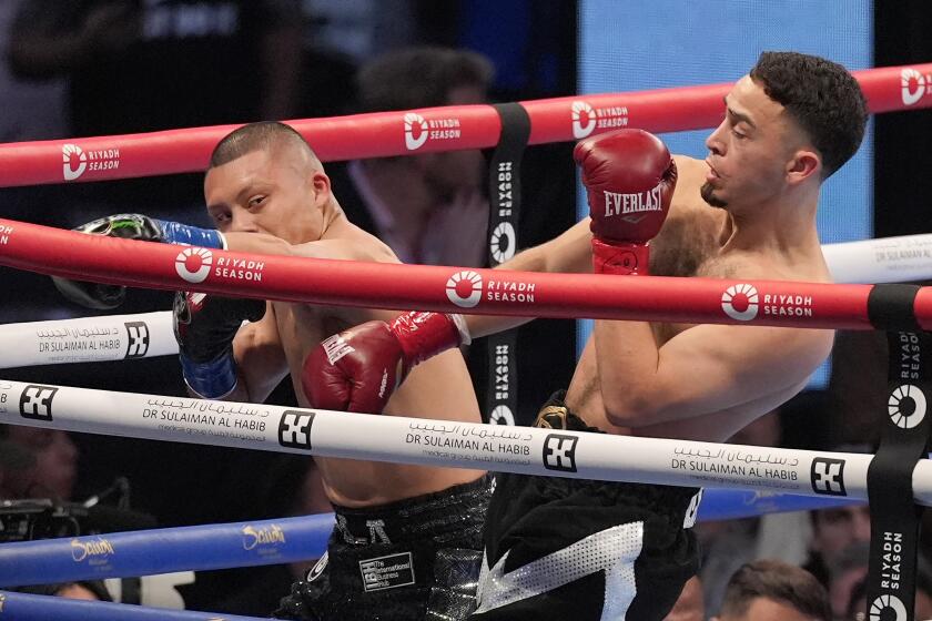 Isaac Cruz, left, fights Jose Valenzuela, right, during a super lightweight championship boxing match in Los Angeles, Saturday, Aug. 3, 2024. (AP Photo/Damian Dovarganes)