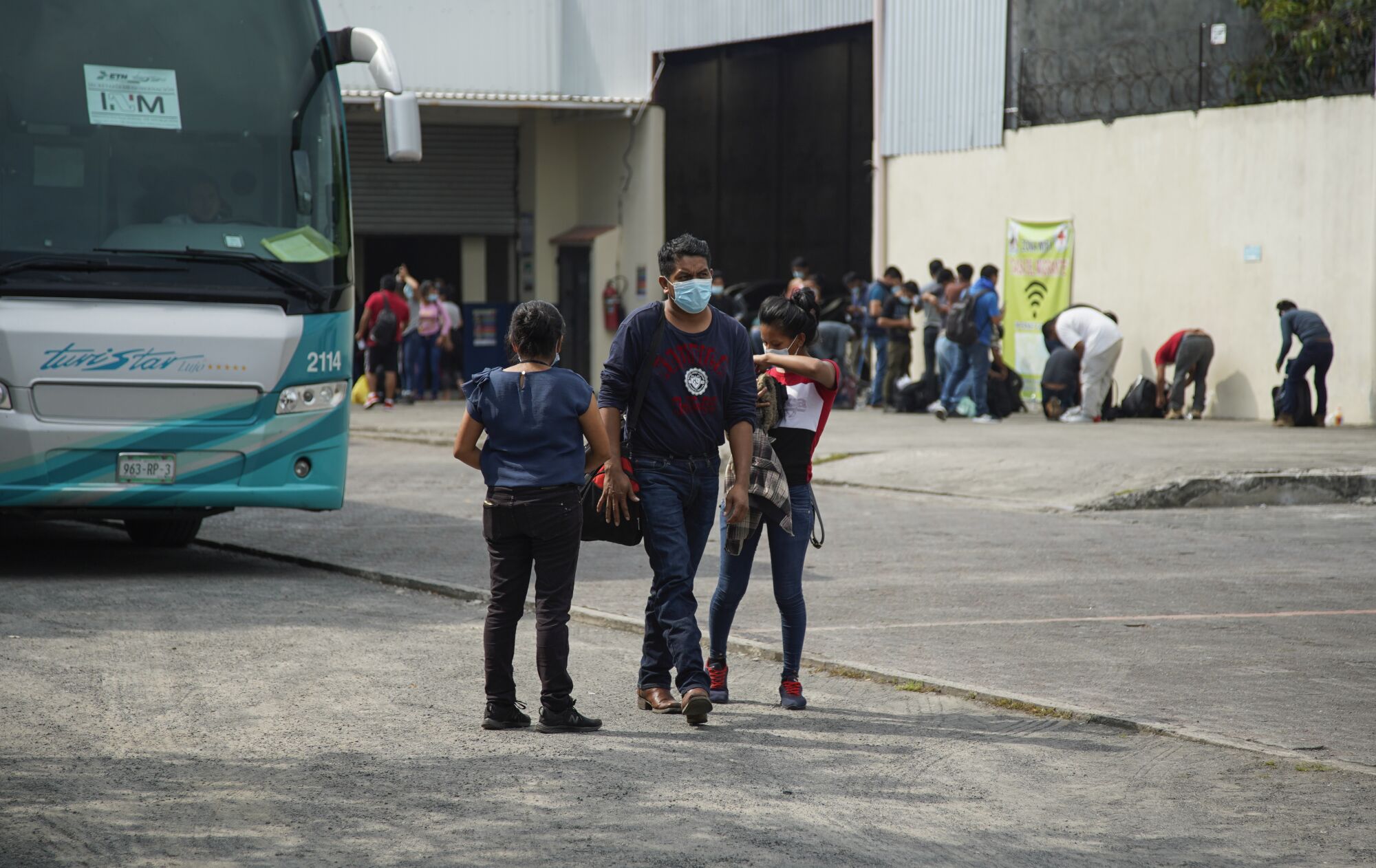 Guatemalan migrants gather their belongings and walk out of the migrant service center after being sent back from Mexico