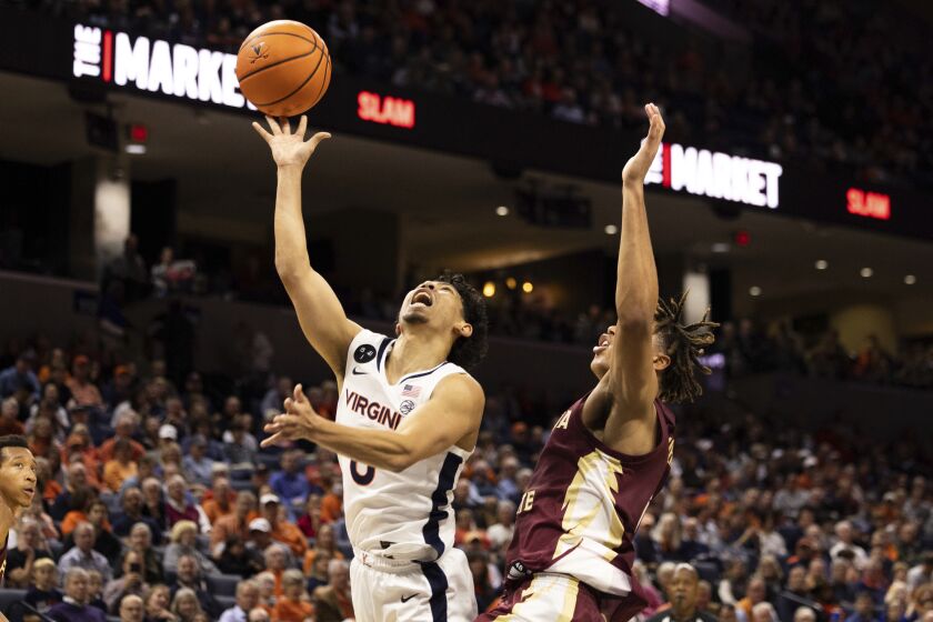 Virginia's Kihei Clark (0) fights for a basket against Florida State during the second half of an NCAA college basketball game in Charlottesville, Va., Saturday, Dec. 3, 2022. (AP Photo/Mike Kropf)