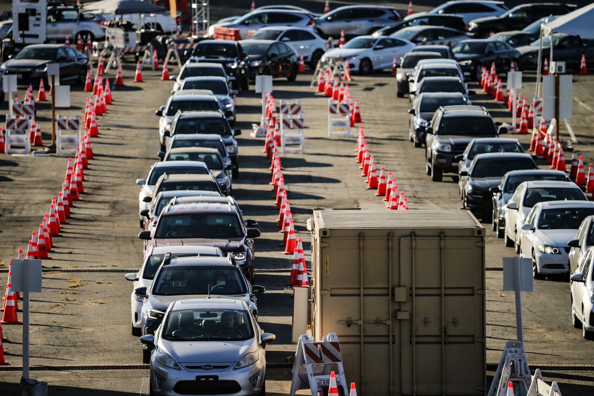 Waiting cars stack up in lines between orange traffic cones in Dodger Stadium's parking lot.