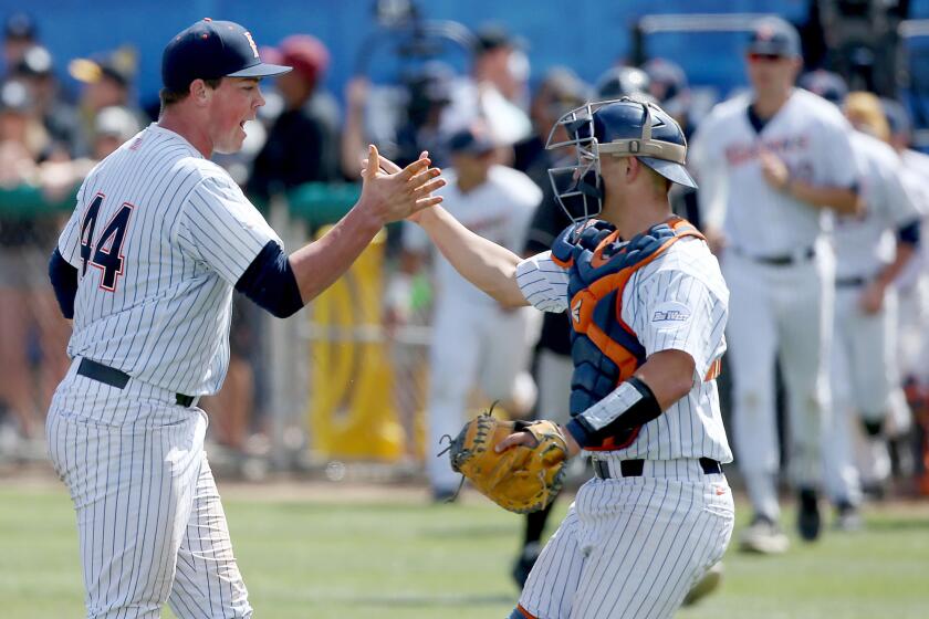 Fullerton pitcher John Gavin and catcher Chris Hudgins celebrate after defeating Long Beach State on Saturday.