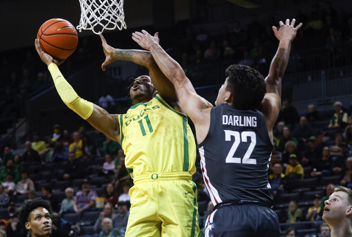 Oregon guard Rivaldo Soares (11) shoots against Washington State guard Dylan Darling (22) during the first half of an NCAA college basketball game in Eugene, Ore., Thursday, Dec. 1, 2022. (AP Photo/Thomas Boyd)
