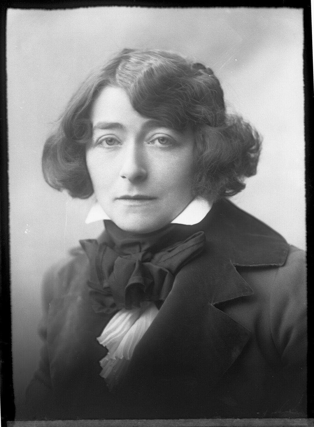 Eileen Gray is seen in a vintage black and white photo wearing a black suit more typical of a man