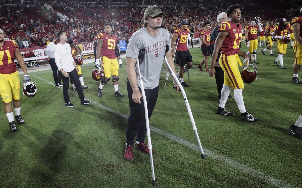 USC quarterback JT Daniels is on crutches as he makes his way onto the field.