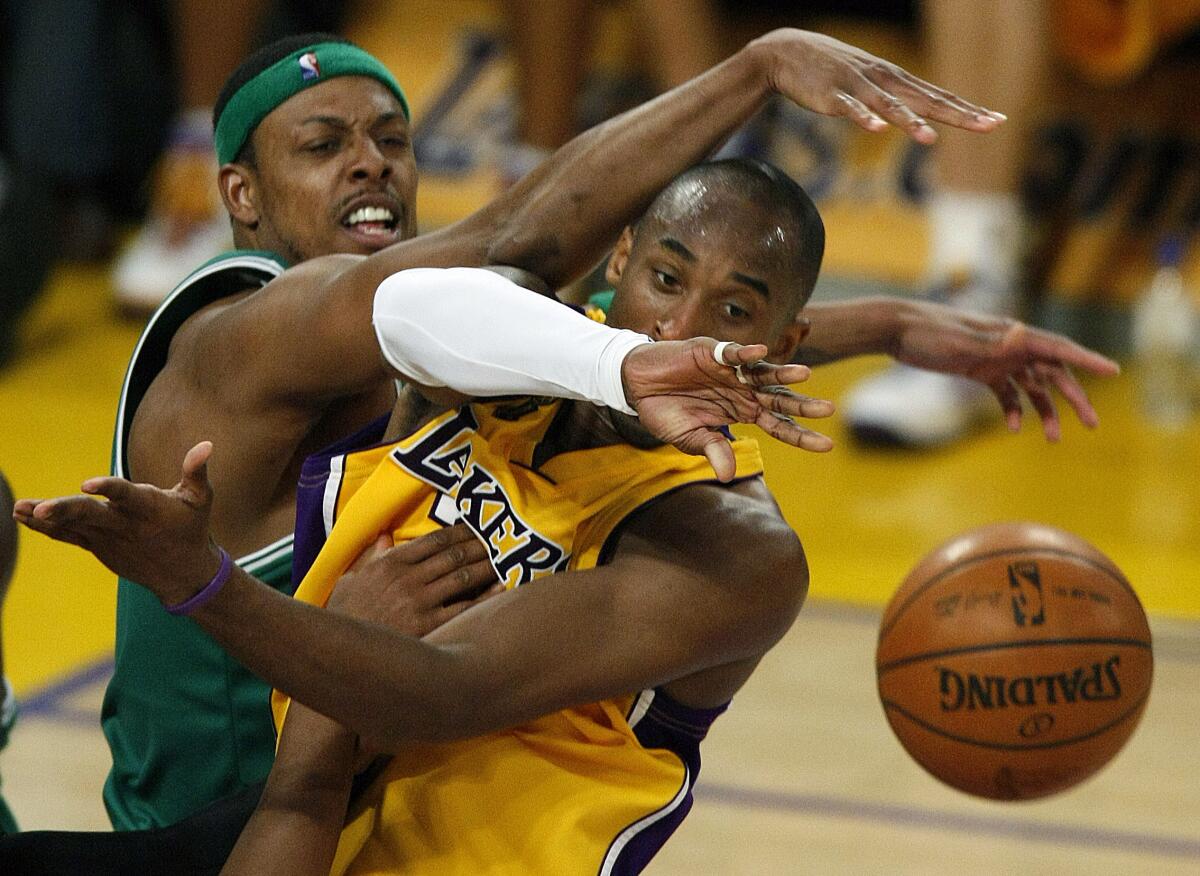 Celtics forward Paul Pierce forces Lakers guard Kobe Bryant to make a pass while driving to the basket.