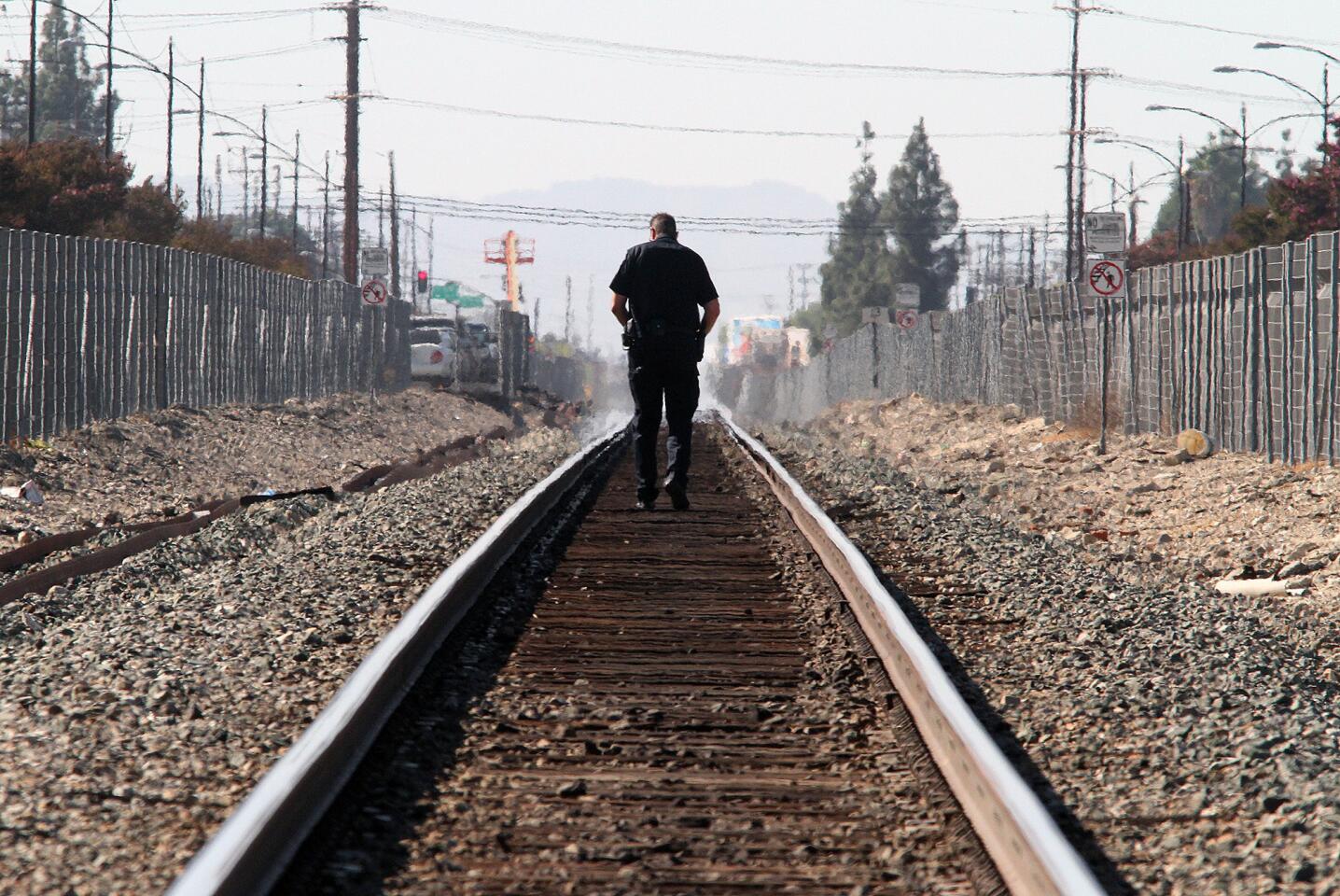 A Burbank police officer walks north observing the tracks where a Metrolink train collided with a motorist at the intersection of San Fernando and Buena Vista in Burbank on Monday, September 2, 2014. The southbound train struck a motorist allegedly driving around the downed crossing arms on Buena Vista, totaling the vehicle and sending the driver to the hospital with critical injuries.