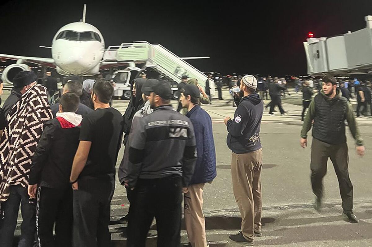 People in the crowd walk shouting antisemitic slogans at an airfield in Makhachkala, Russia.