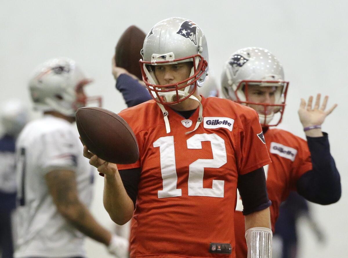 New England quarterback Tom Brady grips a football during practice Sunday in Foxborough, Mass.