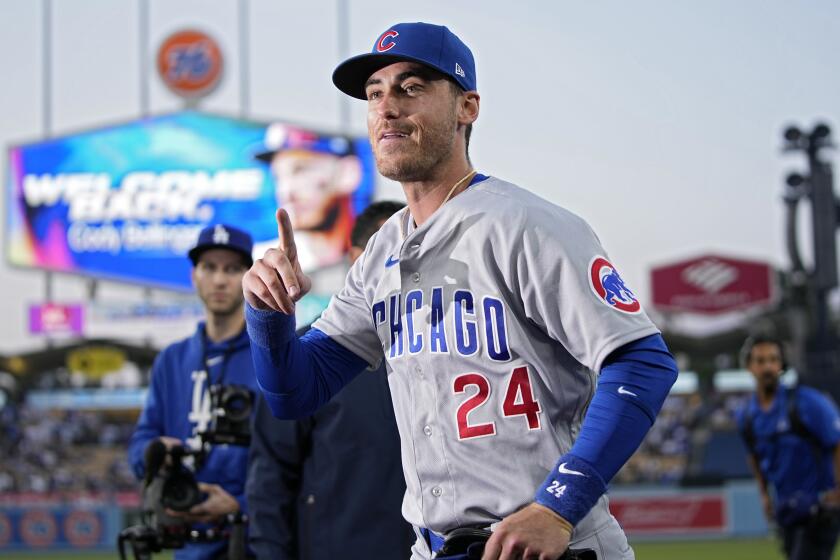 Cubs center fielder Cody Bellinger gestures to the crowd after being acknowledged by the Dodgers prior to a baseball game.