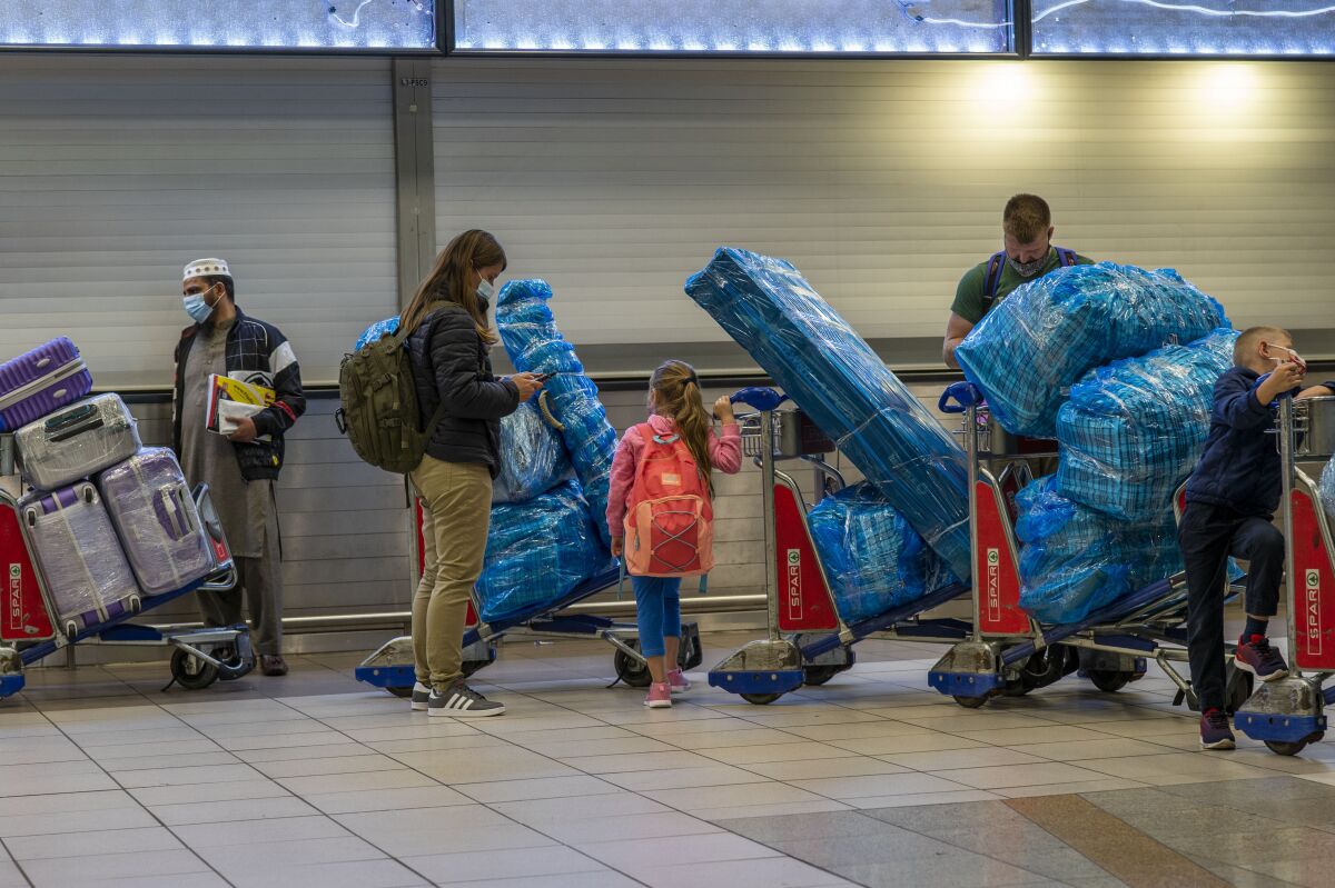 People line up with baggage to get on an overseas flight