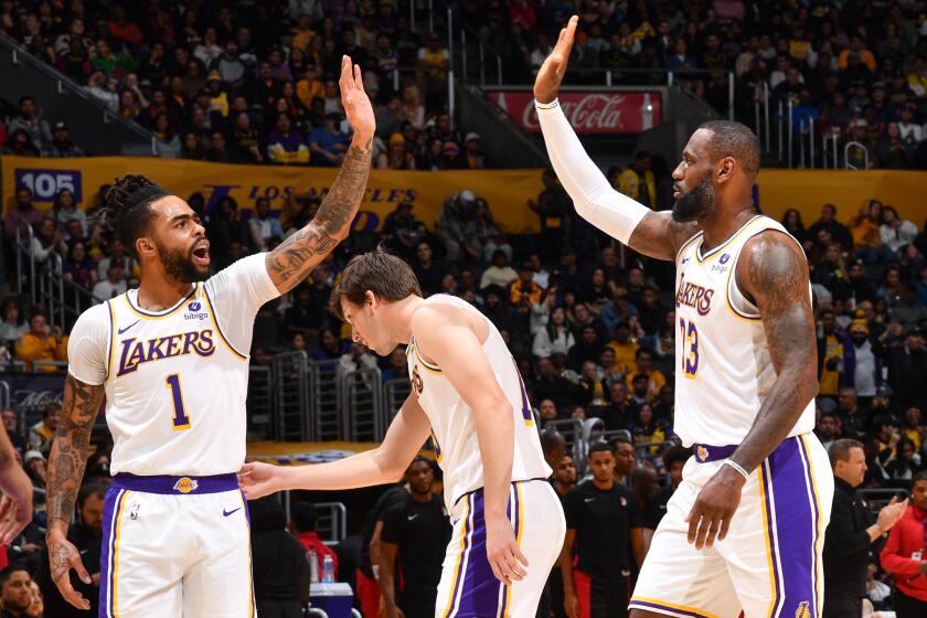 D'Angelo Russell and LeBron James high five as they walk alongside teammates Austin Reaves and Rui Hachimura.
