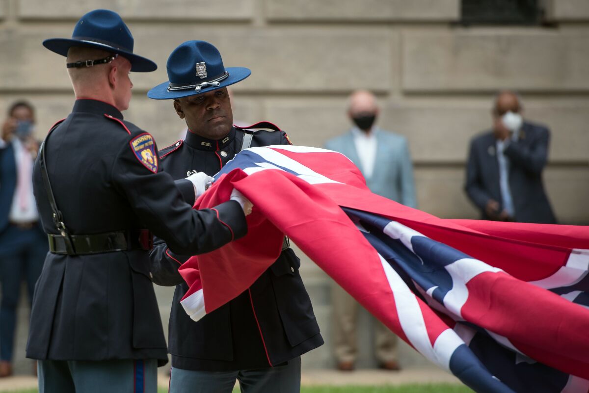 Members of the Mississippi Highway Safety Patrol retire the state flag outside the Mississippi State Capitol building 