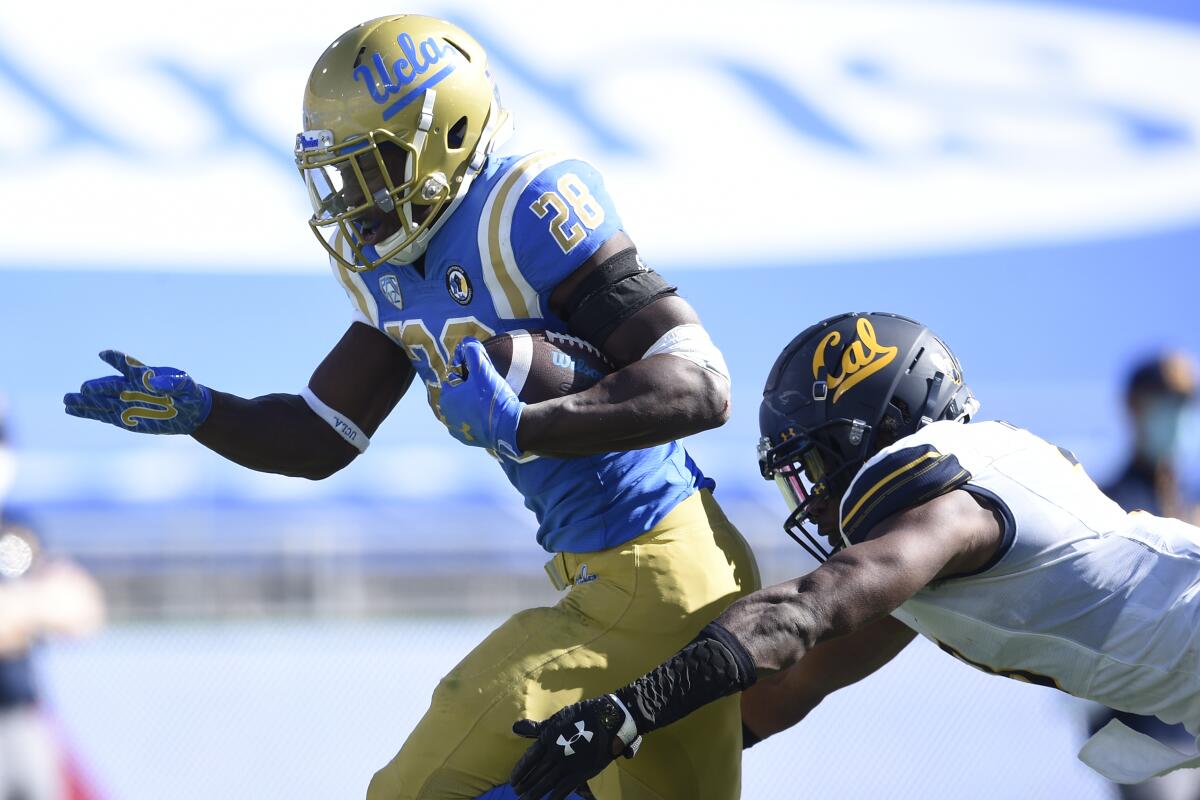 UCLA running back Brittain Brown gets past California safety Elijah Hicks on a 31-yard touchdown Nov. 15, 2020.