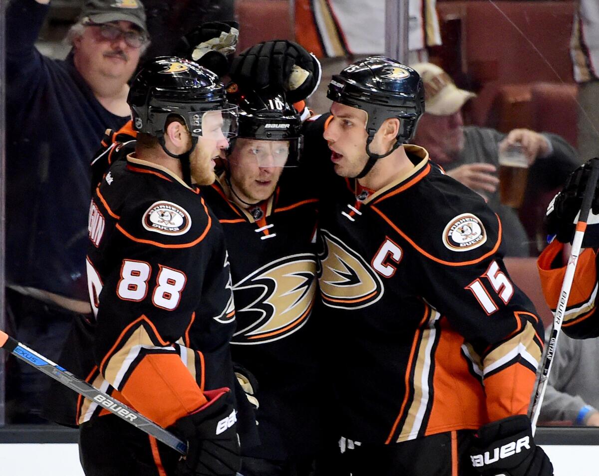 Ducks forwards Jamie McGinn (88), Corey Perry, center, and Ryan Getzlaf celebrate after a goal against the Flames during the first period of a game on March 30.