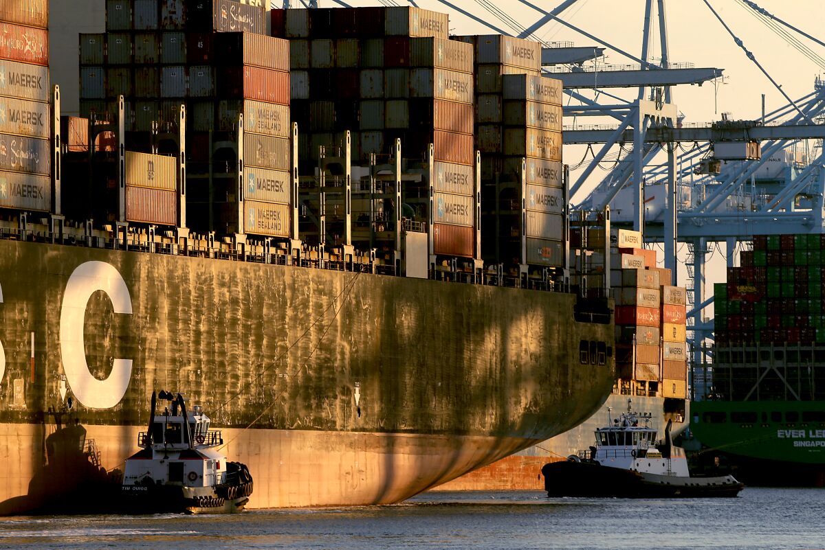 Tugboats maneuver a container ship