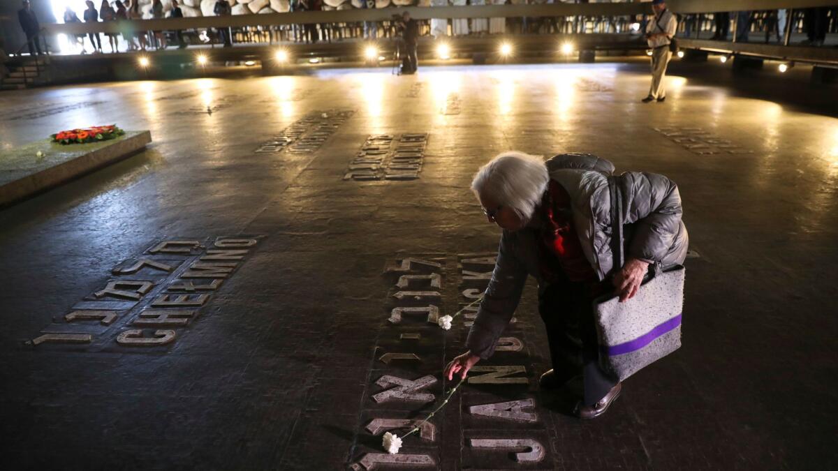 A woman lays a flower at the Yad Vashem Holocaust memorial on remembrance day, in Jerusalem, April 24.