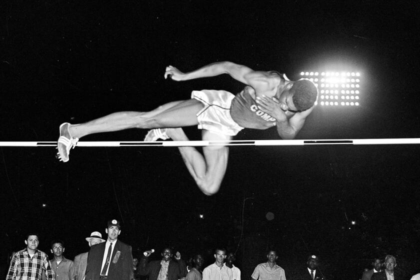 Charles Dumas soars to a new world record with a leap of 7 feet, 1/2 inch during men's high jump competition.